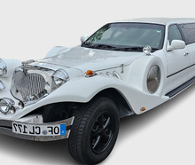 Excalibur Oldtimer Stretchlimousine in Weiß mit rotem Teppich und einer Sektflasche
